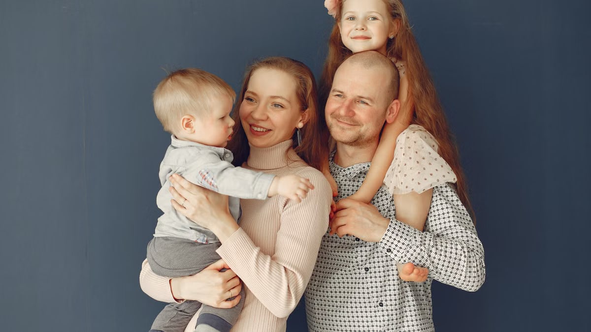 A joyful family portrait showcasing parents and their two children, expressing love and togetherness.